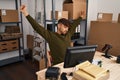 Young arab man ecommerce business worker tired stretching arms at office