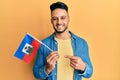Young arab man holding haiti flag smiling happy pointing with hand and finger