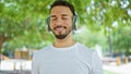 Young arab man listening to music smiling at park Royalty Free Stock Photo