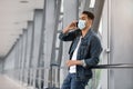 Young Arab Man In Medical Mask Talking On Cellphone In Airport Terminal Royalty Free Stock Photo