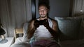 Young arab man playing video game sitting on bed at bedroom Royalty Free Stock Photo