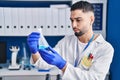 Young arab man scientist measuring liquid at laboratory