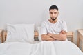 Young arab man sitting on bed with angry expression and arms crossed gesture at bedroom Royalty Free Stock Photo