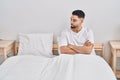 Young arab man sitting on bed with angry expression and arms crossed gesture at bedroom Royalty Free Stock Photo