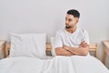 Young arab man sitting on bed with angry expression and arms crossed gesture at bedroom Royalty Free Stock Photo