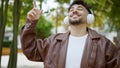 Young arab man smiling confident listening to music and dancing at park Royalty Free Stock Photo