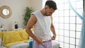 Young arab man standing tired using towel sweating at home