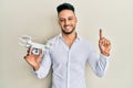Young arab man using drone smiling with an idea or question pointing finger with happy face, number one Royalty Free Stock Photo