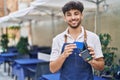 Young arab man waiter using data phone and credit card at restaurant