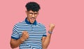 Young arab man wearing casual clothes and glasses excited for success with arms raised and eyes closed celebrating victory smiling Royalty Free Stock Photo