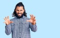 Young arab man wearing casual clothes smiling funny doing claw gesture as cat, aggressive and sexy expression Royalty Free Stock Photo