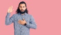 Young arab man wearing casual clothes swearing with hand on chest and open palm, making a loyalty promise oath Royalty Free Stock Photo