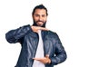 Young arab man wearing casual leather jacket gesturing with hands showing big and large size sign, measure symbol Royalty Free Stock Photo