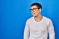 Young arab man wearing casual white shirt and glasses looking away to side with smile on face, natural expression Royalty Free Stock Photo