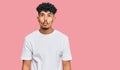 Young arab man wearing casual white t shirt making fish face with lips, crazy and comical gesture Royalty Free Stock Photo