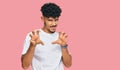 Young arab man wearing casual white t shirt smiling funny doing claw gesture as cat, aggressive and sexy expression Royalty Free Stock Photo