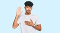 Young arab man wearing casual white t shirt swearing with hand on chest and open palm, making a loyalty promise oath Royalty Free Stock Photo