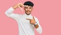 Young arab man wearing casual winter sweater smiling making frame with hands and fingers with happy face Royalty Free Stock Photo