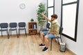 Young arab man wearing neck collar with finger raised up sitting on chair at hospital waiting room Royalty Free Stock Photo