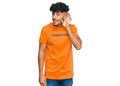 Young arab man wearing tshirt with happiness word message smiling with hand over ear listening an hearing to rumor or gossip