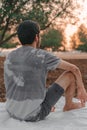 Young Arab model sitting on a white picnic blanket outdoors