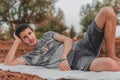 Young Arab model sitting on a white picnic blanket outdoors