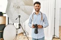 Young arab photographer man smiling happy using reflex camera at photo studio