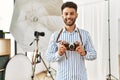 Young arab photographer man smiling happy using vintage camera at photo studio