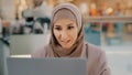 Young arab sorrowful woman in hijab reading message on laptop gets bad news denied bank loan job dismissal bankruptcy