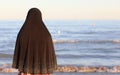 arab woman with black veil to cover her head by the sea awaits t Royalty Free Stock Photo