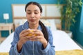 Young arab woman drinking cup of coffee sitting on bed at bedroom Royalty Free Stock Photo