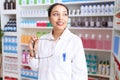 Young arab woman pharmacist smiling confident holding glasses at pharmacy Royalty Free Stock Photo