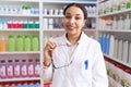 Young arab woman pharmacist smiling confident holding glasses at pharmacy Royalty Free Stock Photo