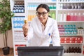 Young arab woman pharmacist using computer holding pills bottle at pharmacy Royalty Free Stock Photo