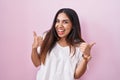 Young arab woman standing over pink background success sign doing positive gesture with hand, thumbs up smiling and happy Royalty Free Stock Photo