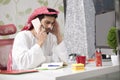 Young Arabian business man talking on mobile phone and working finance about cost with laptop computer.