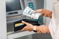 Young arabian female got dollars at atm machine, folds money in wallet outdoor, cropped Royalty Free Stock Photo