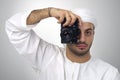 Young Arabian man using holding his camera ready to shoot, isolated Royalty Free Stock Photo