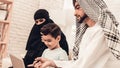 Young Arabic Family Using Laptop on Sofa at Home.