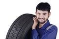 Young Arabic mechanic carrying a tire Royalty Free Stock Photo