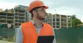 Young architect or builder man standing with digital touchpad on the construction site and analyzing scheme project plan Royalty Free Stock Photo