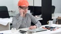 Young architect in helmet having important phone call Royalty Free Stock Photo