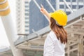 Young architect woman in yellow helmet standing at the city, Female engineer at building construction site Royalty Free Stock Photo