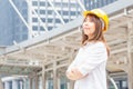 Young architect woman in yellow helmet standing at the city, Female engineer at building construction site Royalty Free Stock Photo