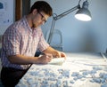 Young architect working on drawing table in architect studio.