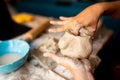 Young artisan woman working at home with clay, a manual work that requires craftsmanship and skills, also a hobby and a pastime