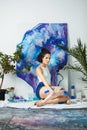 Young artist creates new artwork sitting on floor. Serious woman Royalty Free Stock Photo