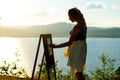 Young artist draws a seascape at sunset Royalty Free Stock Photo