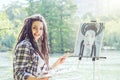 Young artist girl painting a self portrait in a park near lake - Painter woman with dreadlocks hairstyle working on her art