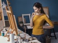 Young artist watching her painting on the easel Royalty Free Stock Photo